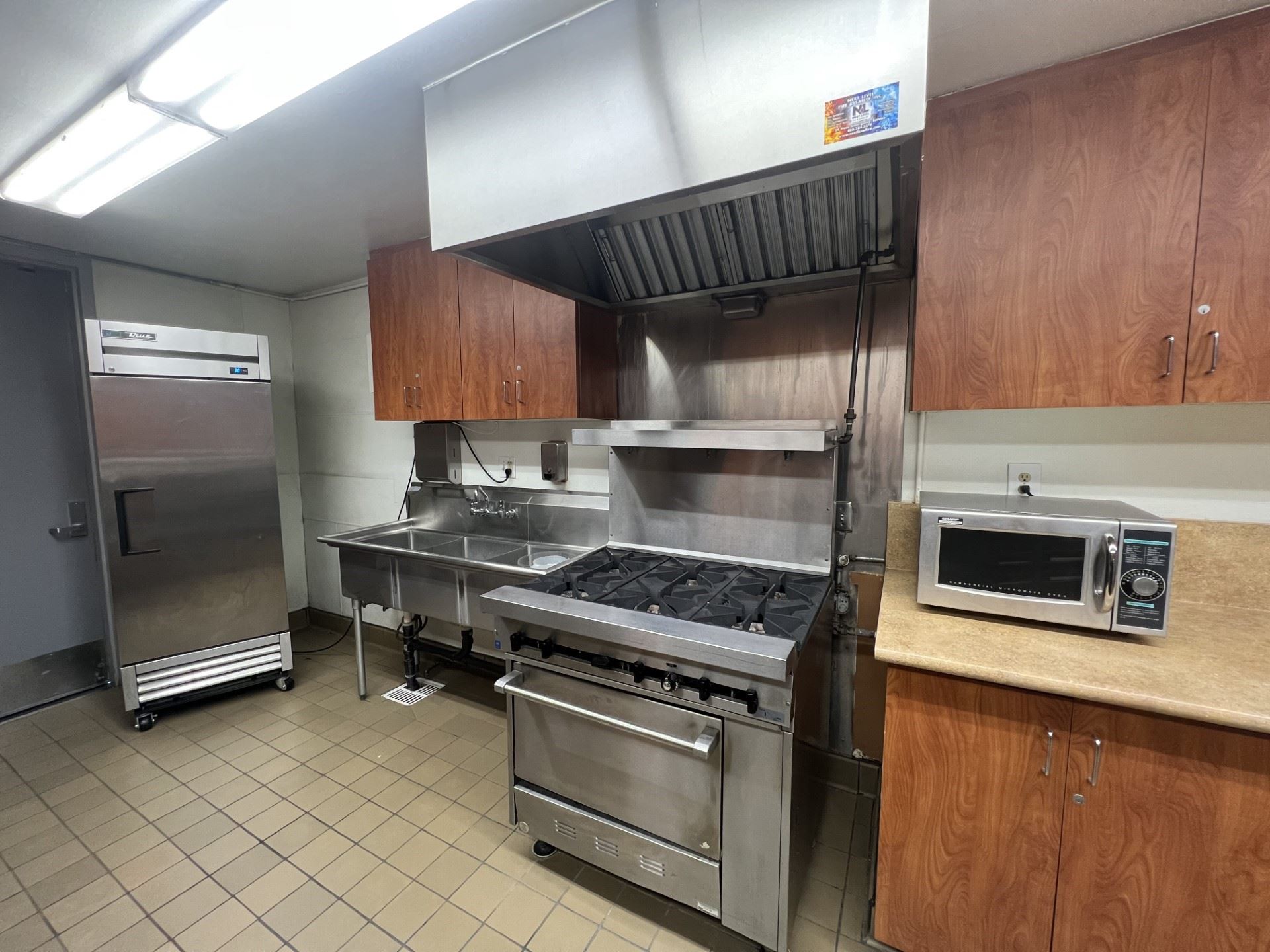 Don Day Center kitchen showing the microwave, stove, refrigerator and counters.